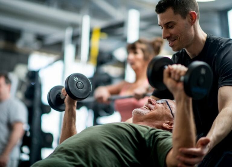 Coach with client dumbbell press